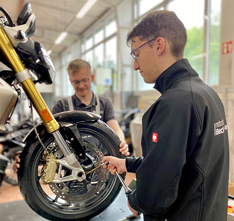 zwei BMW Motorrad Mechaniker bei der Arbeit