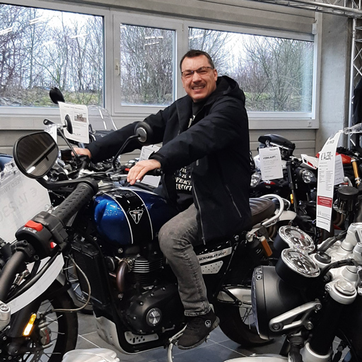 Kunde auf einer Triumph Scrambler 1200 im Schauraum Paderborn